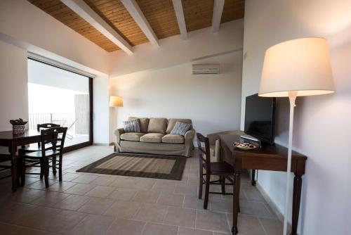 een woonkamer met een bank en een tafel bij La Dimora di Spartivento - BW Signature Collection in Ragusa