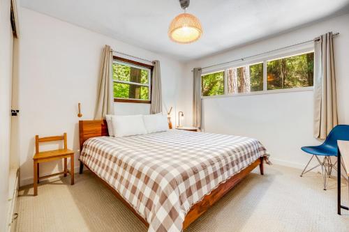 a bedroom with a bed and two windows at Caz Cabin 6 in Cazadero