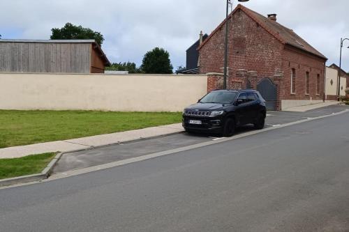 a black car parked on the side of a street at Dormir à l'usine Loft industriel Atypique in Saint-Quentin-Lamotte-Croix-au-Bailly