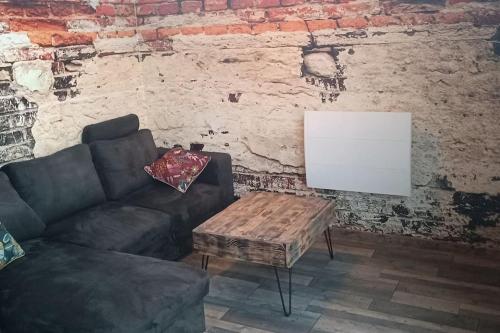 a living room with a couch and a table at Dormir à l'usine Loft industriel Atypique in Saint-Quentin-Lamotte-Croix-au-Bailly