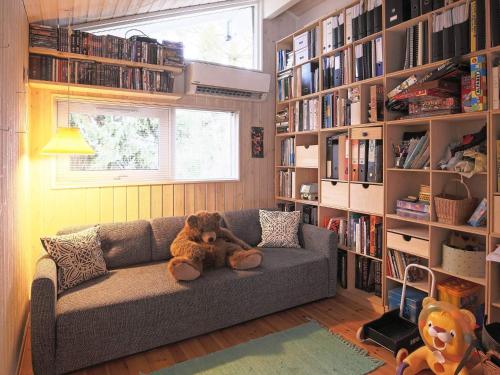 a teddy bear sitting on a couch in a library at 8 person holiday home in Tisvildeleje in Tisvildeleje