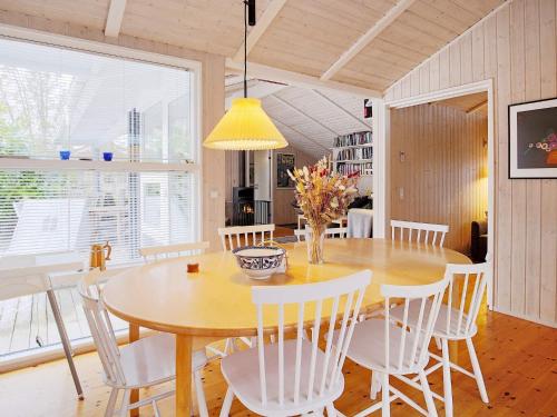 a dining room with a wooden table and white chairs at 8 person holiday home in Tisvildeleje in Tisvildeleje