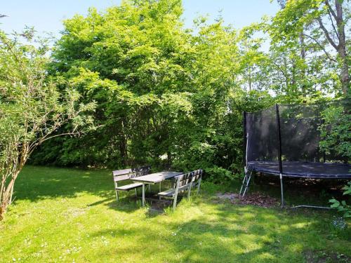 a picnic table and a bench in a yard at 8 person holiday home in Tisvildeleje in Tisvildeleje