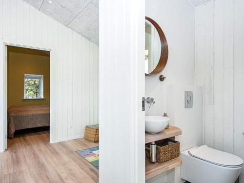 a white bathroom with a toilet and a sink at Two-Bedroom Holiday home in Rømø 17 in Rømø Kirkeby