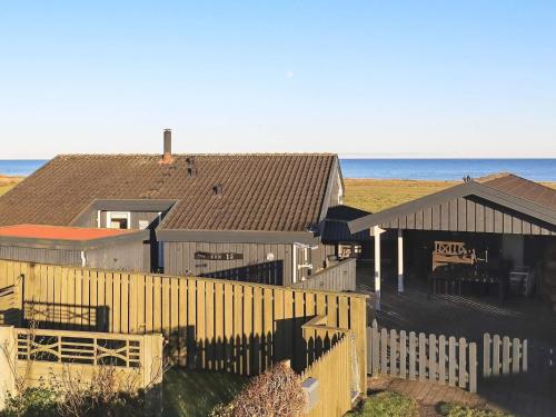 un grupo de casas detrás de una valla cerca del océano en 8 person holiday home in S by en Sæby