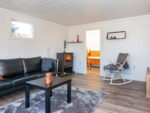 salon z czarną kanapą i kominkiem w obiekcie 7 person holiday home in B rkop w mieście Børkop