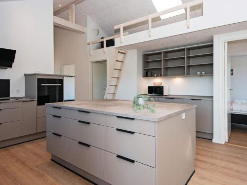 a kitchen with white cabinets and a loft bed at 12 person holiday home in Ansager-By Traum in Ansager