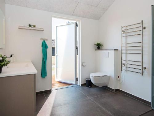 La salle de bains est pourvue de toilettes, d'un lavabo et d'une douche. dans l'établissement Holiday home Ansager XXXVIII, à Ansager