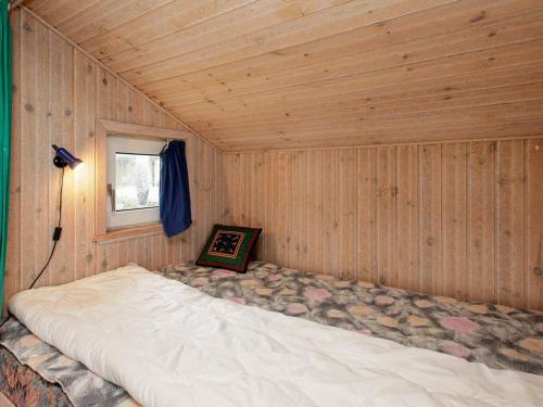 a large bed in a wooden room with a window at Holiday home Vinderup in Vinderup
