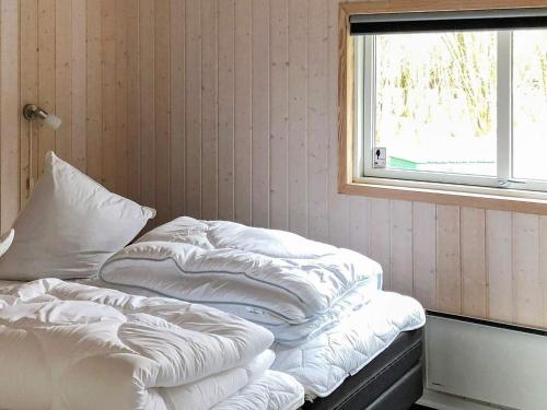 an unmade bed in a room with a window at 8 person holiday home in Ansager in Ansager