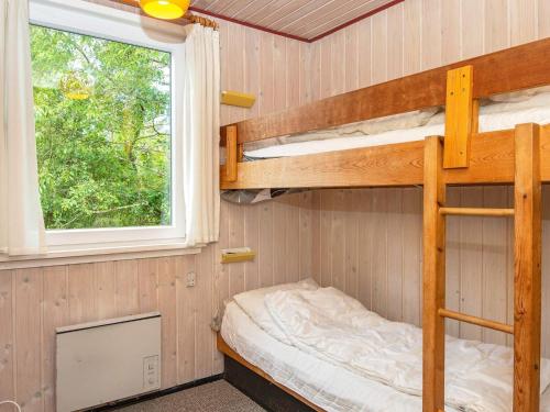 a bunk bed in a tiny house with a window at Holiday home Henne CXXVII in Henne Strand