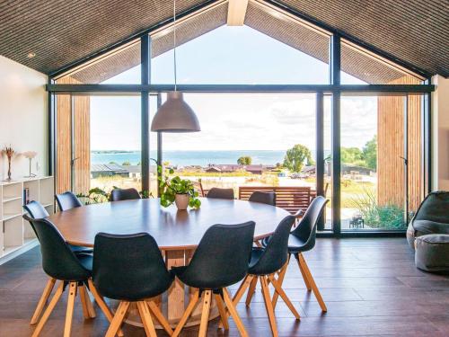una sala da pranzo con tavolo e sedie e una grande finestra di Panoramic Retreat with Pool - By Traum Ferienwohnungen a Sjølund