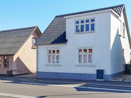 6 person holiday home in Frederikshavn في فريكشهاون: بيت ابيض على جانب شارع
