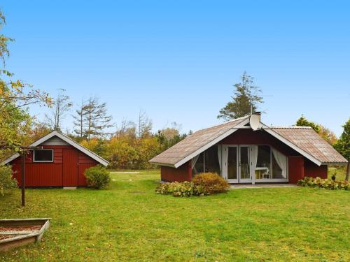 ein kleines rotes Haus mit einem grünen Hof in der Unterkunft 5 person holiday home in Ulfborg in Ulfborg
