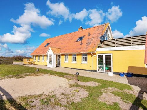 a yellow house with an orange roof at 12 person holiday home in Lemvig in Ferring