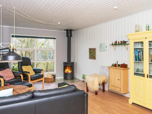ein Wohnzimmer mit einem Sofa und einem Kamin in der Unterkunft 6 person holiday home in Knebel in Knebel