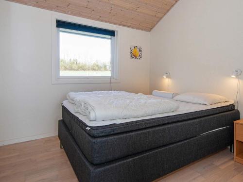 Un dormitorio con una cama en una habitación con ventana. en 6 person holiday home in Nordborg, en Nordborg