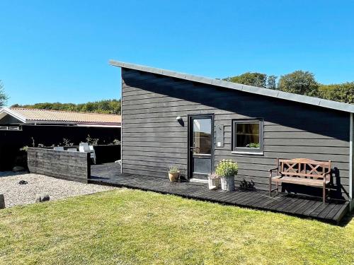 a small house with a bench on a deck at 6 person holiday home in Bjert in Sønder Bjert