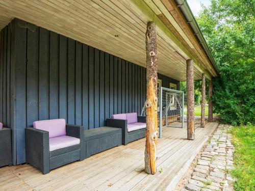 a covered deck with two chairs and a pole at 10 person holiday home in Ry-By Traum in Ry