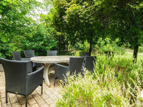a table and chairs in a garden with trees at 10 person holiday home in Ry-By Traum in Ry