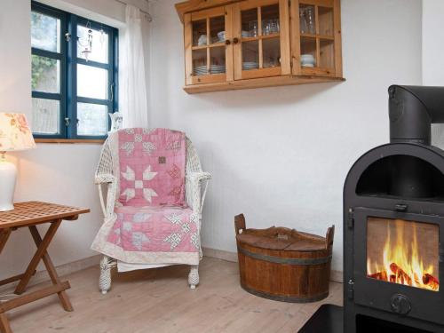 a living room with a wood stove and a chair at 5 person holiday home in Bog By in Bogø By