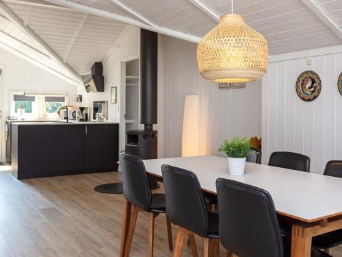 ein Esszimmer und eine Küche mit einem Tisch und Stühlen in der Unterkunft 6 person holiday home in Str by in Strøby