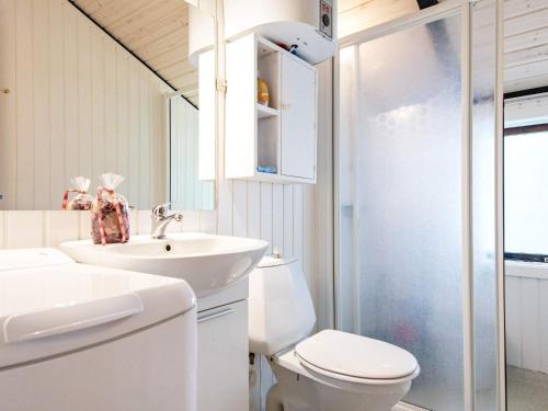 a white bathroom with a sink and a toilet at Holiday home Oksbøl LXXVIII in Oksbøl