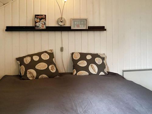 a bedroom with a bed and two pillows at Holiday home Væggerløse CCXIII in Marielyst