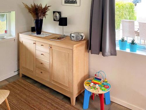 a room with a dresser and a table with a toy at Holiday home Otterup XXII in Otterup