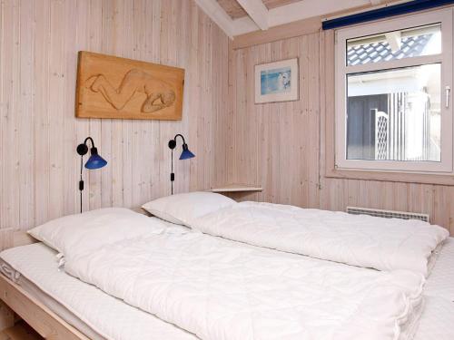 1 dormitorio con 1 cama blanca grande y ventana en Two-Bedroom Holiday home in Hjørring 1, en Lønstrup