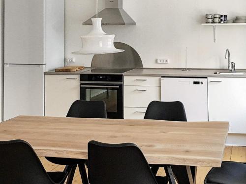 a kitchen with a wooden table and black chairs at 4 person holiday home in Nakskov in Nakskov