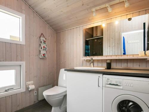 a bathroom with a toilet and a sink and a washing machine at 6 person holiday home in Hjørring-By Traum in Vester Vidstrup