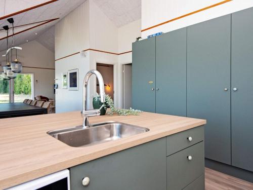 a kitchen with blue cabinets and a sink at 12 person holiday home in Ansager-By Traum in Ansager