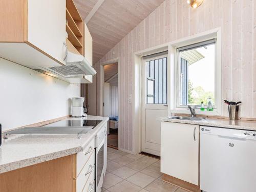 a kitchen with white counters and a window and a sink at 6 person holiday home in Rudk bing in Spodsbjerg