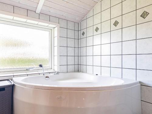 a bath tub in a bathroom with a window at 6 person holiday home in Rudk bing in Spodsbjerg