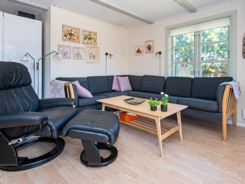 ein Wohnzimmer mit einem Sofa und einem Tisch in der Unterkunft 6 person holiday home in Ulfborg in Ulfborg