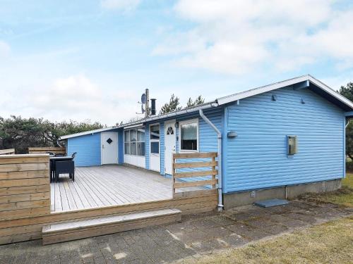 uma casa azul com um grande deque em 6 person holiday home in S by em Sæby