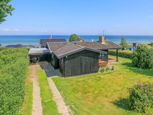 una vista aérea de una casa con el océano en el fondo en 6 person holiday home in Hesselager, en Hesselager