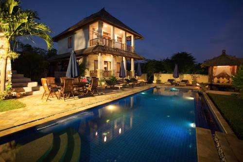 a house with a swimming pool in front of a house at Tanah At Ulus in Uluwatu