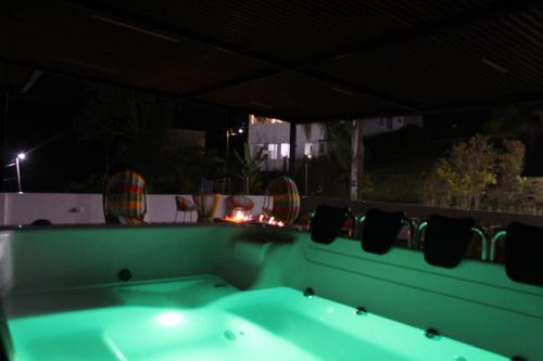 una vasca da bagno verde seduta su un balcone di notte di Nueva, Moderna casa en Silvania con Jacuzzi a Silvania