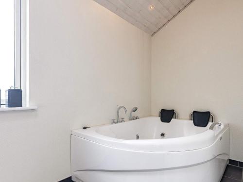 a white bath tub in a bathroom with a window at 8 person holiday home in Skals in Hjarbæk