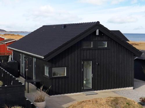 uma casa preta com um telhado preto em 5 person holiday home in Frederikshavn em Frederikshavn