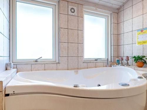 baño con bañera blanca y 2 ventanas en 6 person holiday home in lb k en Ålbæk