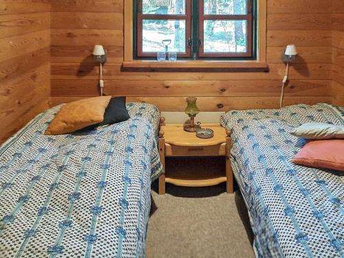 een slaapkamer met 2 bedden, een tafel en een raam bij Holiday home Hadsund CVIII in Hadsund