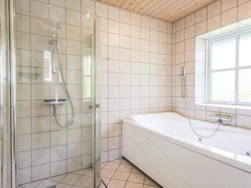 a bathroom with a shower and a tub and a sink at Holiday home Nørre Nebel CXLII in Nørre Nebel