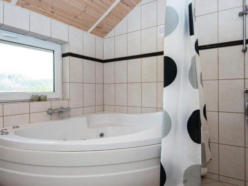 a white bath tub in a bathroom with a window at 8 person holiday home in Oksbøl-By Traum in Oksbøl