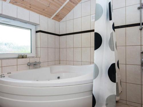 a white bath tub in a bathroom with a window at Holiday home Oksbøl LXXXIII in Oksbøl