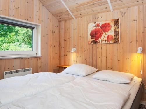 1 dormitorio con cama blanca y ventana en Holiday home Oksbøl LXXXIII, en Oksbøl