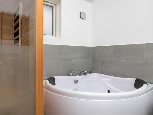 uma banheira branca na casa de banho ao lado de um chuveiro em 6 person holiday home in L kken em Lokken
