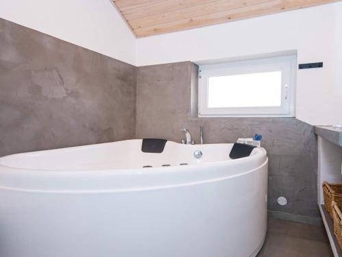 a white bath tub in a bathroom with a window at 8 person holiday home in Glesborg in Glesborg